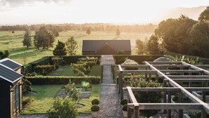 Uma casa moderna com vista para um campo verde e árvores.