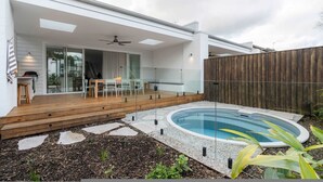 A modern house with a covered patio, a swimming pool, and a wooden deck. - Rubus Green Berry - by Linnaeus Collection (Berry)