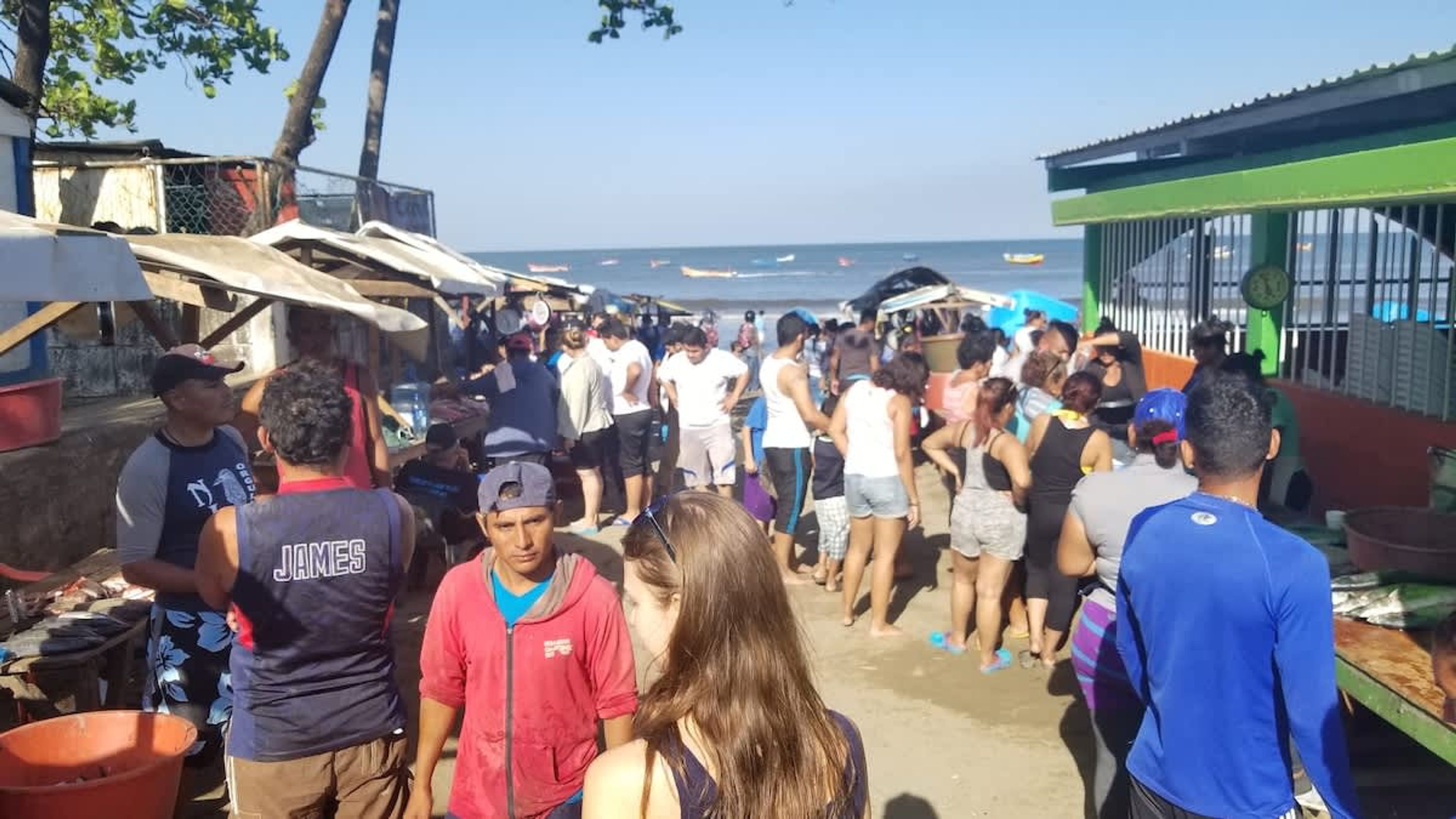 Un mercado al aire libre concurrido, donde la gente camina e interactúa.