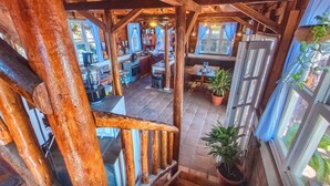 A rustic wooden interior with a staircase leading to a dining area and kitchen. - Balcony Bedroom Suite w Romantic Sunsets - AC - Pool (San Rafael del Sur)