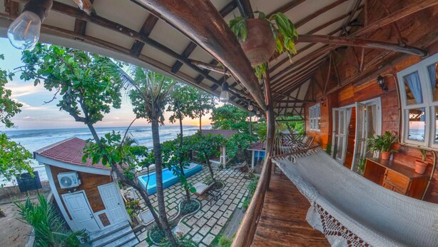 A wooden veranda with a hammock, a pool, and a view of the sea. - Balcony Bedroom Suite w Romantic Sunsets - AC - Pool (San Rafael del Sur)