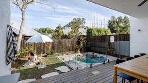 A backyard with a wooden deck, a hot tub, and a small pool. - Rubus Blue Berry - by Linnaeus Collection (Berry)