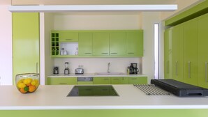 A modern kitchen with green cabinets, a white countertop, a sink, a coffee maker, and a fruit bowl. - VIP Villa Panoramic Seaview Close to Beaches (Ermionida)