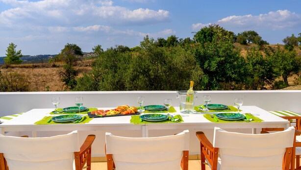 A table set for a meal with a scenic view of trees and hills in the background. - VIP Villa Panoramic Seaview Close to Beaches (Ermionida)