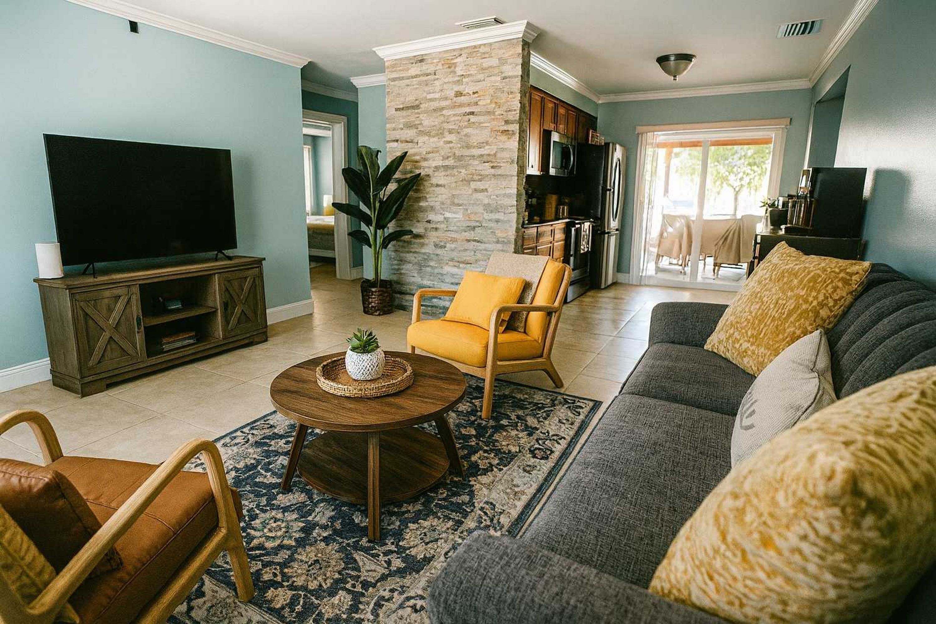 A living room with a television, sofa, armchairs, and a coffee table.