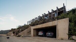A modern building with a concrete staircase leading to a covered parking area. - Casa UNO - Cuatro Cuatros (Ensenada)