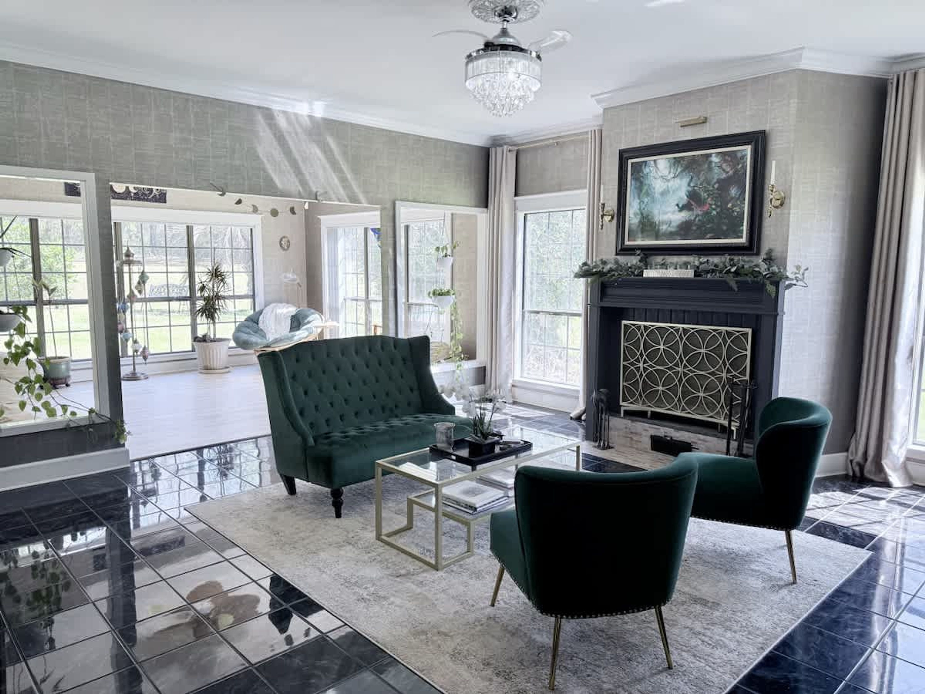 A spacious living room with a fireplace, a large window, and a green sofa.