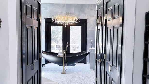 A modern bathroom with a freestanding bathtub, a chandelier, and a large window. - Southern Charm House Min From Shopping Beaches (Fairhope)