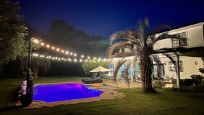 A backyard with a swimming pool, string lights, and a house. - Southern Charm House Min From Shopping Beaches (Fairhope)