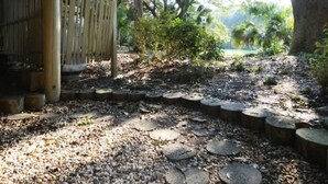 A covered wooden structure with a gravel path leading to a natural setting. - The Breeze in Seabrook Island (Seabrook Island)