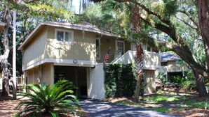 A two-story house with a front porch, an American flag, and a mailbox. - Best Value in Seabrook - Heron Run (Seabrook Island)