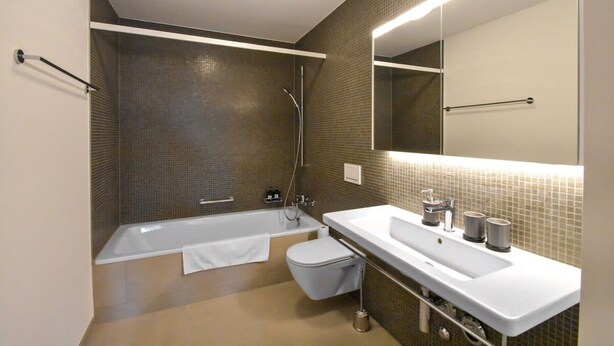 A modern bathroom with a bathtub, toilet, and sink. - Dream View Apt With Homecinema Netflix Loggia (Kriens)