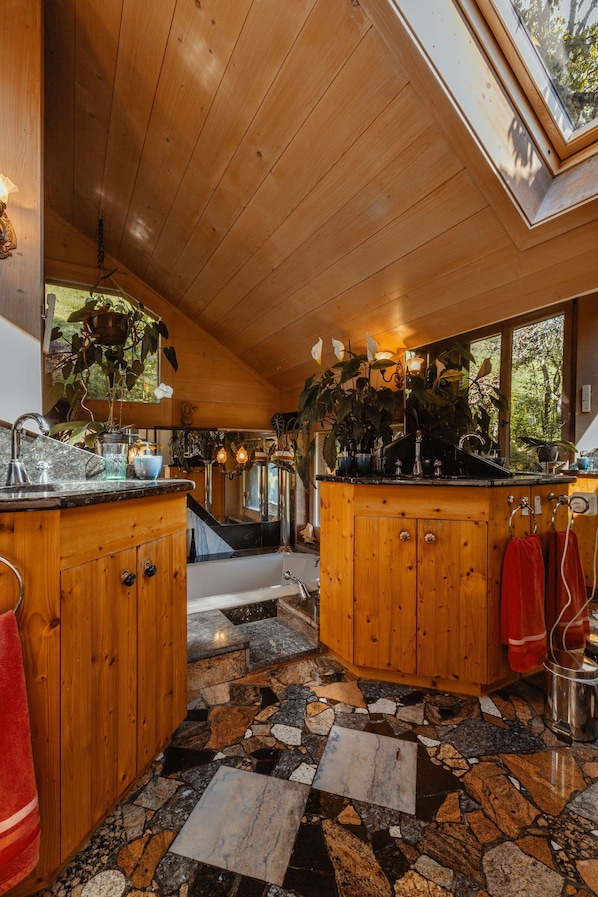 Un interior de madera con suelo de losas de piedra, armarios de madera y un ventanal grande.
