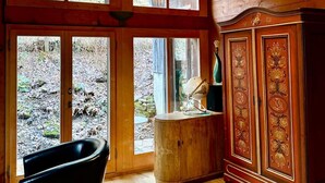Une pièce dotée de planchers en bois, d’une baignoire noire et d’un meuble en bois aux motifs complexes.
