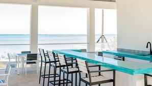 Una cocina moderna con una isla grande, taburetes de bar y vistas al océano.