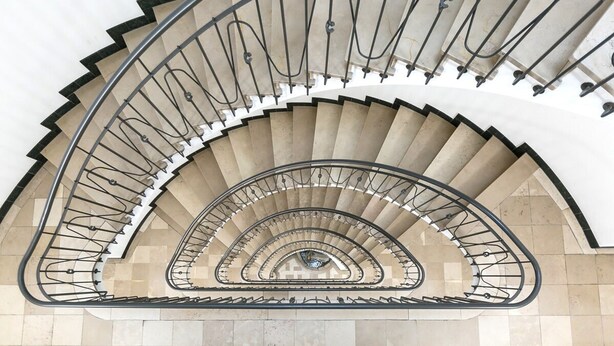 A spiral staircase with a metal railing and beige steps. - Modern Flat w Netflix Balcony top Location (Lucerne)