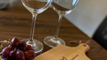 Dos copas de vino vacías sobre una mesa de madera con una tabla de cortar de madera que dice 'airhosted home sharing'.