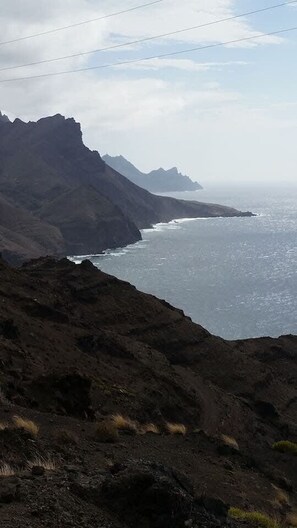 A coastal landscape with rugged cliffs and a view of the ocean.