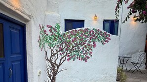 A building with a blue door, a stone staircase, and a wall painted with a tree and flowers. - 4BR Heaven Close to Nature and Ocean in Quiet Setting (Agaete)