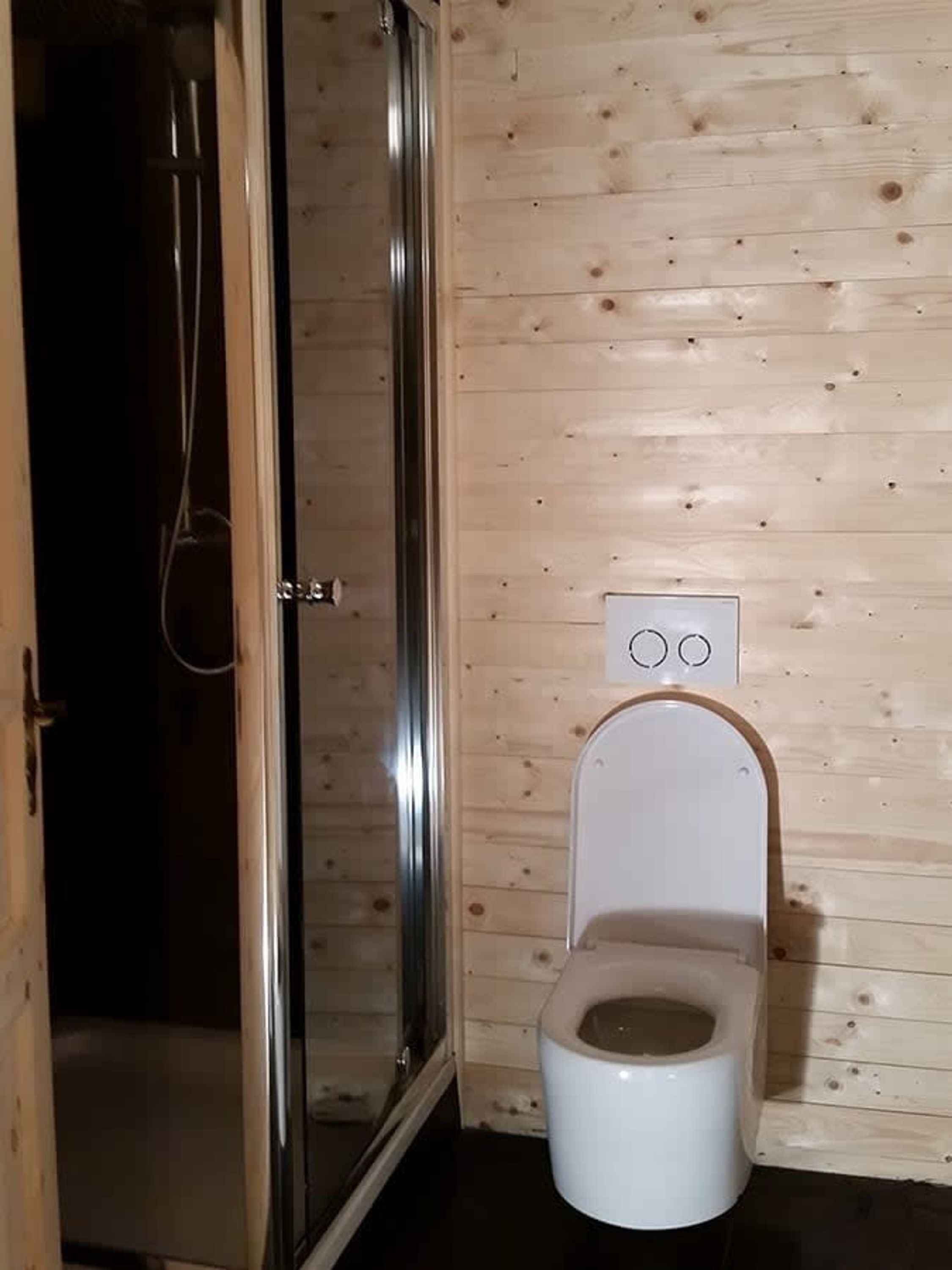 Un baño pequeño y cerrado con ducha y retrete.