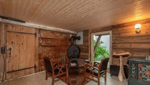 A rustic wooden interior with a fireplace, wooden chairs, and a table. - Alps Chalet for Big Group With Sauna Yoga Terrace (Rossiniere)