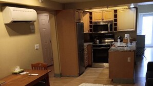 Une chambre d’hôtel de taille réduite, comprenant un lit, une table à manger et une kitchenette.