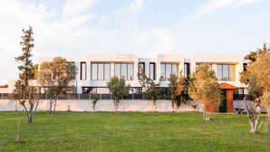 A modern building with a flat roof, large windows, and a well-maintained lawn.