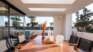 A modern dining area with a wooden table, black mesh chairs, and a decorative centerpiece.