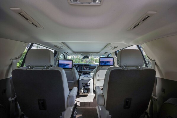 A vehicle interior with two seats, a central console, and a sunroof.