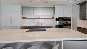 Una cocina moderna con una isla grande, electrodomésticos integrados y un diseño minimalista.