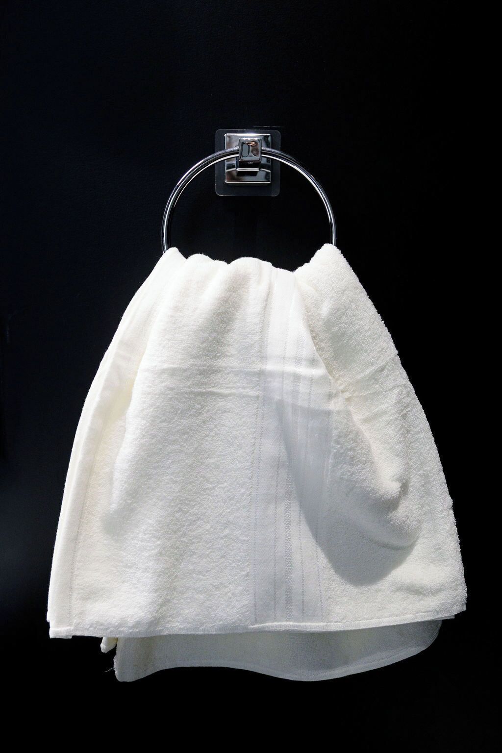 A white towel hanging on a metal hook.