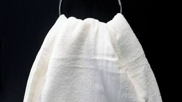 A white towel hanging on a metal hook.
