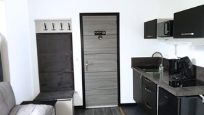 A compact kitchen with a built-in microwave, a coffee maker, and a sink. - SEE - Gare de Marly (Valenciennes)