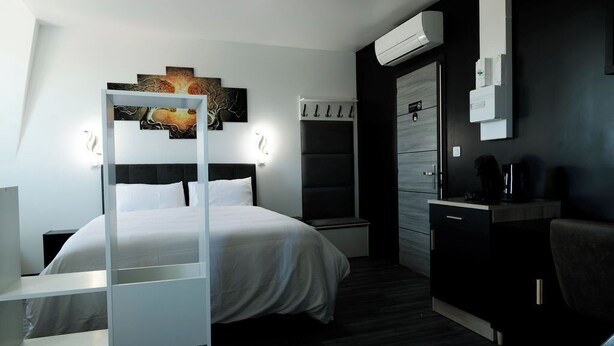 A modern hotel room with a bed, bedside tables, a desk, and a wardrobe. - SEE - Gare de Marly (Valenciennes)