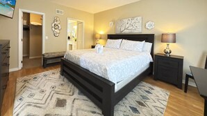 A bedroom with a large bed, a ceiling fan, a nightstand with a lamp, and a dresser. - Near Disney Villa 3 bd Private Pool (Davenport)