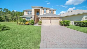 A two-story house with a garage, a paved driveway, and well-maintained landscaping.