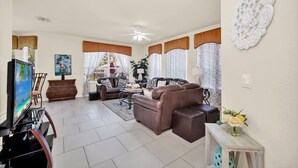 A living room with a sofa, TV, and decorative items.