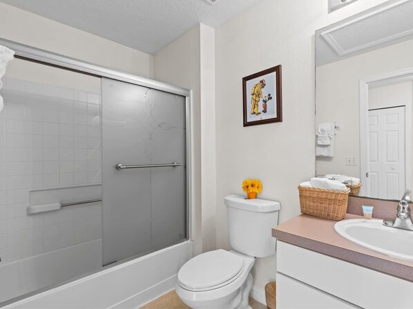 A bathroom with a shower, toilet, sink, and a framed picture on the wall. - 4bd Villa Near Epic Universe and Disney With Private Pool (Kissimmee)