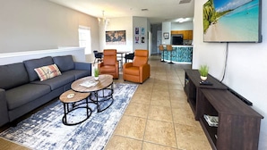 A modern living room with a sofa, armchairs, a coffee table, and a TV. - Very Near Disney 3 Bd Condo Walmart 1 min Away (Kissimmee)