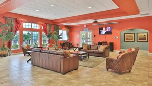 A spacious lobby with a high ceiling, large windows, and a seating area with sofas and armchairs. - Very Near Disney 3 Bd Condo Walmart 1 min Away (Kissimmee)
