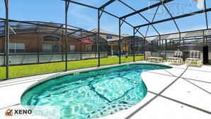 A swimming pool with a glass enclosure, surrounded by outdoor seating and a view of neighboring buildings.