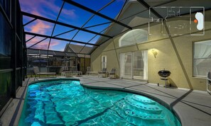 A swimming pool with a glass ceiling, lounge chairs, and a barbecue area. - Private Pool Oasis With King Bed (Kissimmee)
