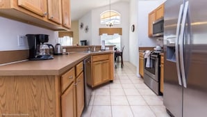 A modern kitchen with wooden cabinets, stainless steel appliances, and a large island.