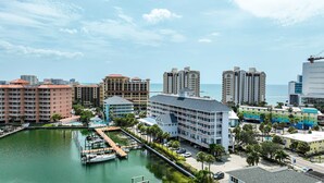 A marina with boats docked, a hotel with multiple floors and balconies, and a view of the ocean. - 445 Clearwater Hamden (Clearwater Beach)