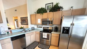 Una cucina moderna con mobili in legno, elettrodomestici in acciaio inossidabile e una lavastoviglie.
