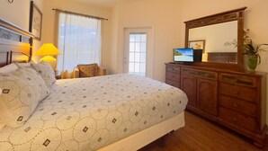 A bedroom with a bed, a dresser, a television, and a window with curtains. - 4Bd Pool Villa in Calabay Parc Close to Disney Sleeps 8 (Haines City)