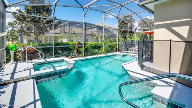 A pool area with a glass-enclosed structure, a hot tub, and a lounge area with outdoor seating. - 4Bd Pool Villa in Calabay Parc Close to Disney Sleeps 8 (Haines City)