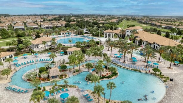 Ein Resort mit mehreren Schwimmbecken, Palmen und Liegebereichen.