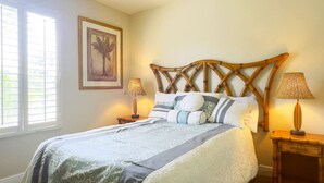Un dormitorio con una cama grande, dos lámparas de noche, un cuadro enmarcado en la pared y una ventana con persianas.