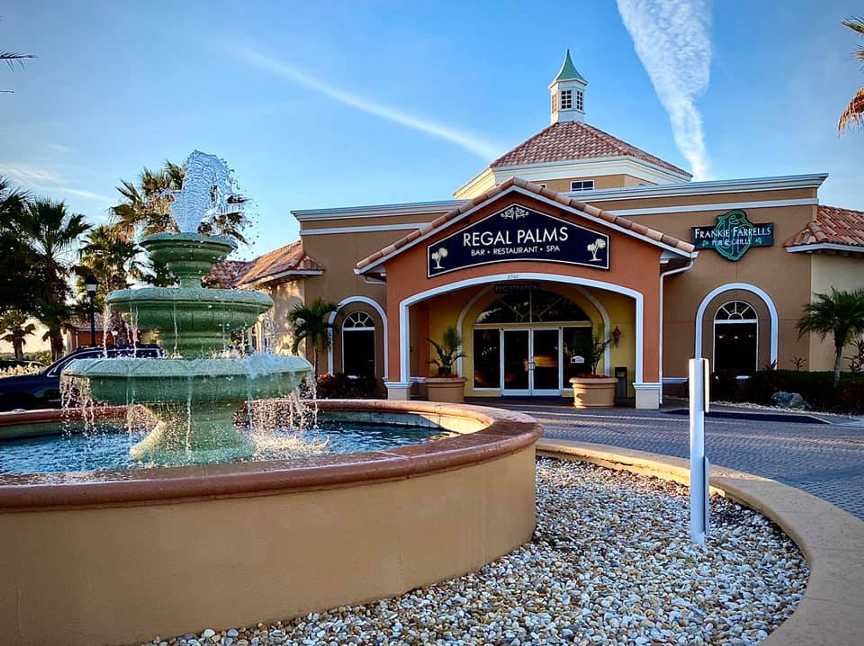 A building with a sign reading "Regal Palms Bar, Restaurant, Spa".
